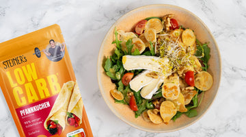 Ein bunter Salat mit Rucola, kleinen Tomaten, Sprossen, Camembert und kleinen Mini-Pancakes aus STEINER´s Pfannkuchen-Backmischung.