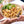 Laden Sie das Bild in den Galerie-Viewer, STEINER´s Low Carb High Protein Fusilli zubereitet als mediterraner Nudelsalat mit Artischocke und Tomaten. Die Pasta ist in einer weißen Servierschüssel. Diese Schüssel wird von einer Person zu einer weiteren Person gereicht.