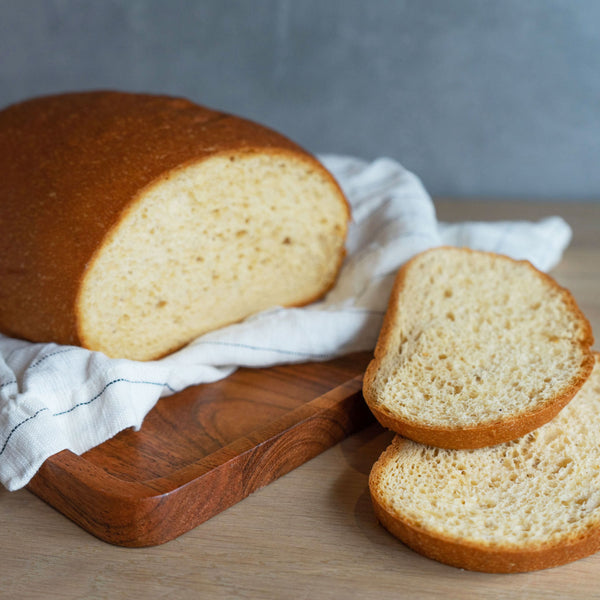 Ein aufgeschnittenes Laib STEINER´s Low Carb High Protein Toast auf einem weißen Küchentuch