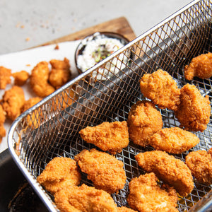 STEINER´s Semmelbrösel als Rezeptidee: Nuggets aus Schwein, panniert und frittiert mit STEINER´s Semmelbrösel. Die Nuggets liegen auf einem Küchentuch. Daneben ist ein Frischkäse-Dipp.