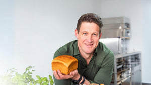 Olympiasieger Matthias Steiner im grünen Hemd hält ein STEINER´s Low Carb Toast Brot in seiner Hand und lächelt in die Kamera