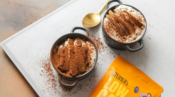 Zwei graue Schälchen mit unserem Cheesecake Dessert, das mit Kakao getoppt wurde.