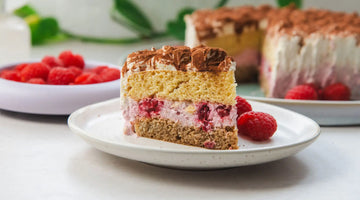 Ein Stück Low Carb Himbeer-Tiramisu in Herzform mit Kakao bestreut.