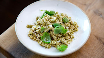 STEINER´s Fusilli mit Pasikilumpesto und frischen Basikikumblättern auf einem weißen Teller.