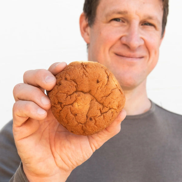 Matthias Steiner hält ein Zwiebelbrötchen richtung Kamera.